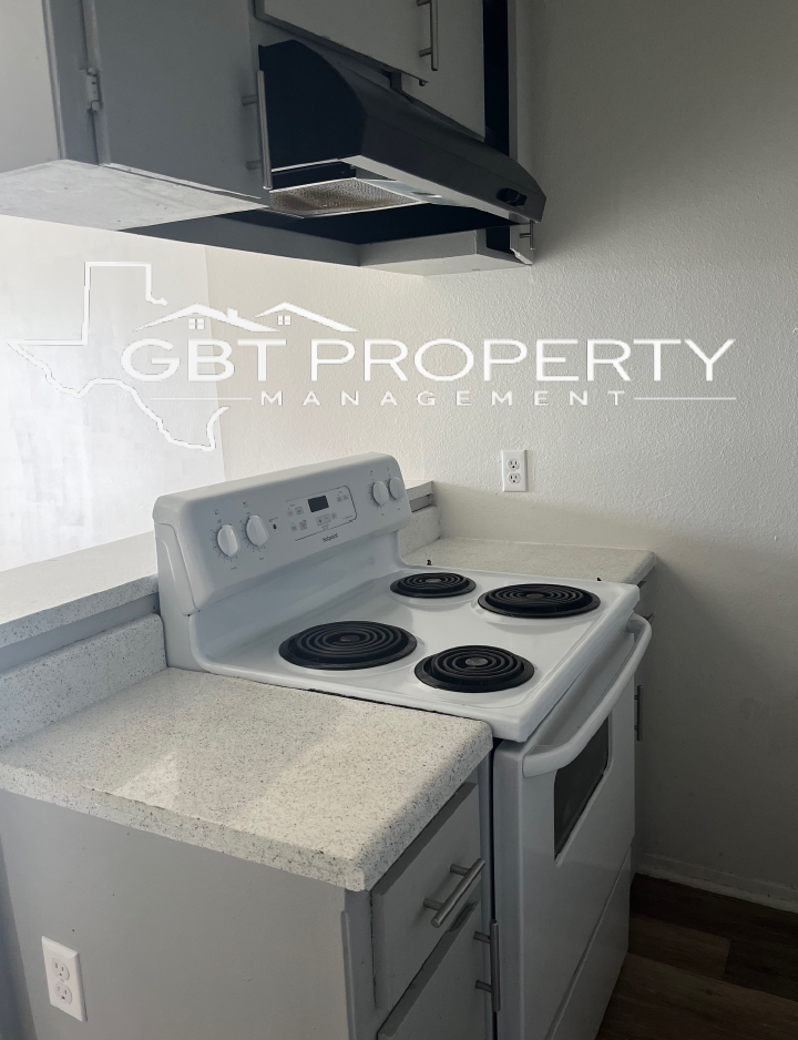 A white stove and oven in a kitchen with a hood above it.