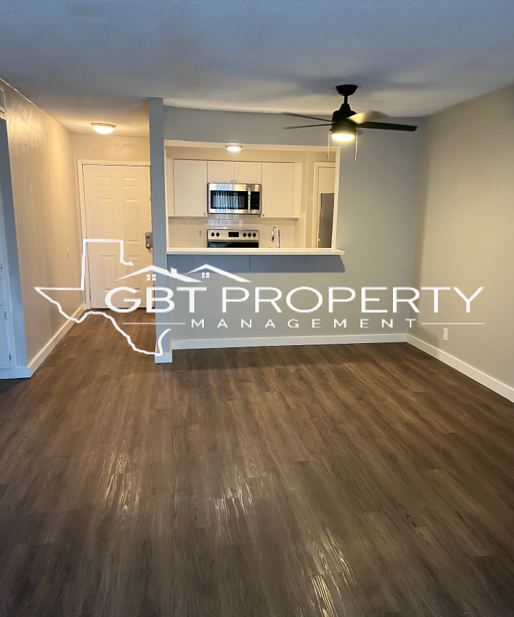 A living room with a ceiling fan and the words gbt property management on the bottom