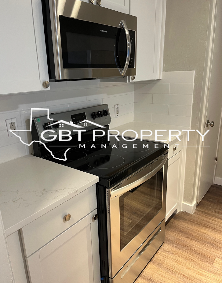 A kitchen with a stove , microwave , and oven.