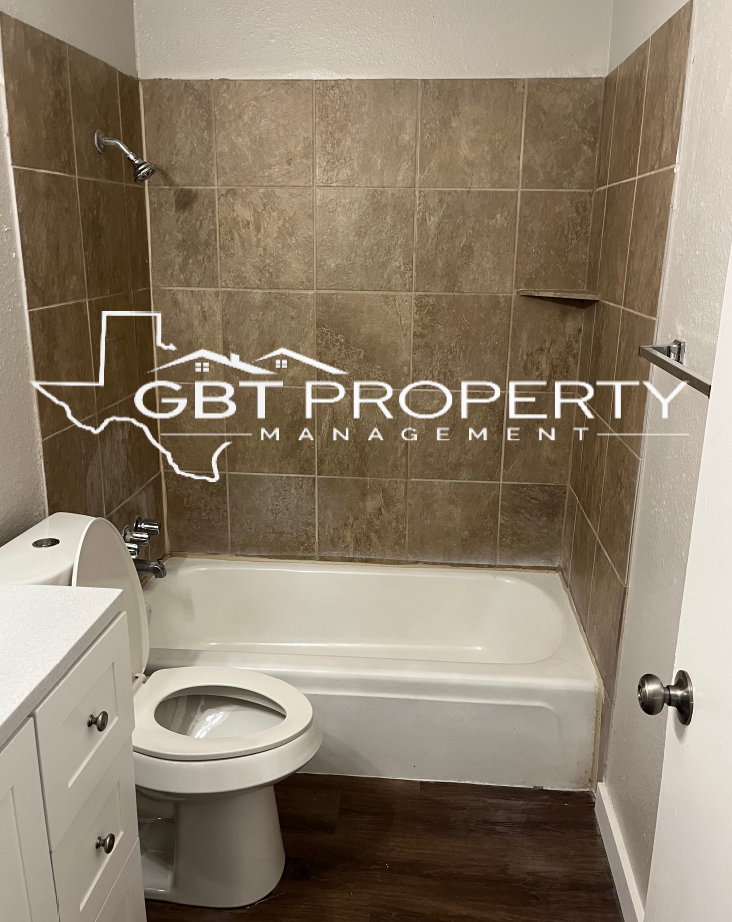 A bathroom with a toilet , bathtub and shower.