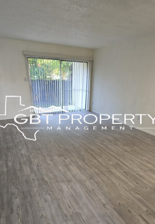 A living room with hardwood floors and a sliding glass door.