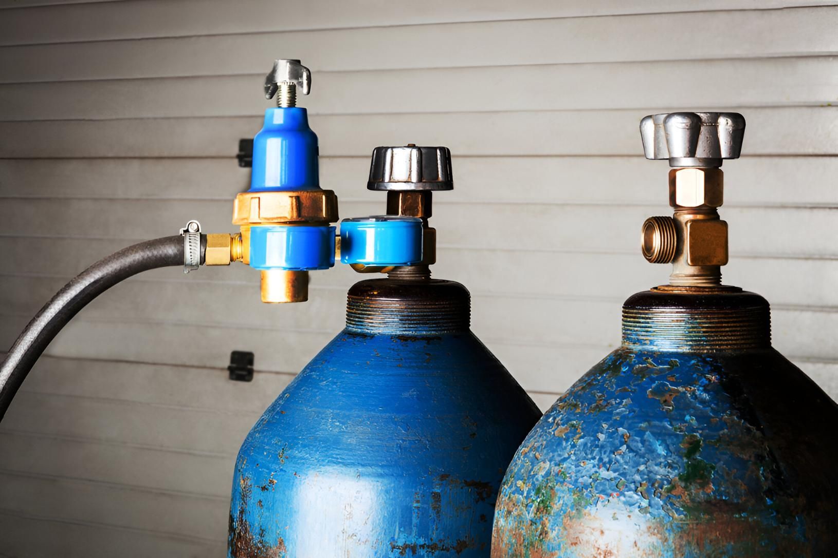Two Blue Gas Cylinders Are Sitting Next to Each Other in A Garage — Delaney Plumbing Services In Taree, NSW