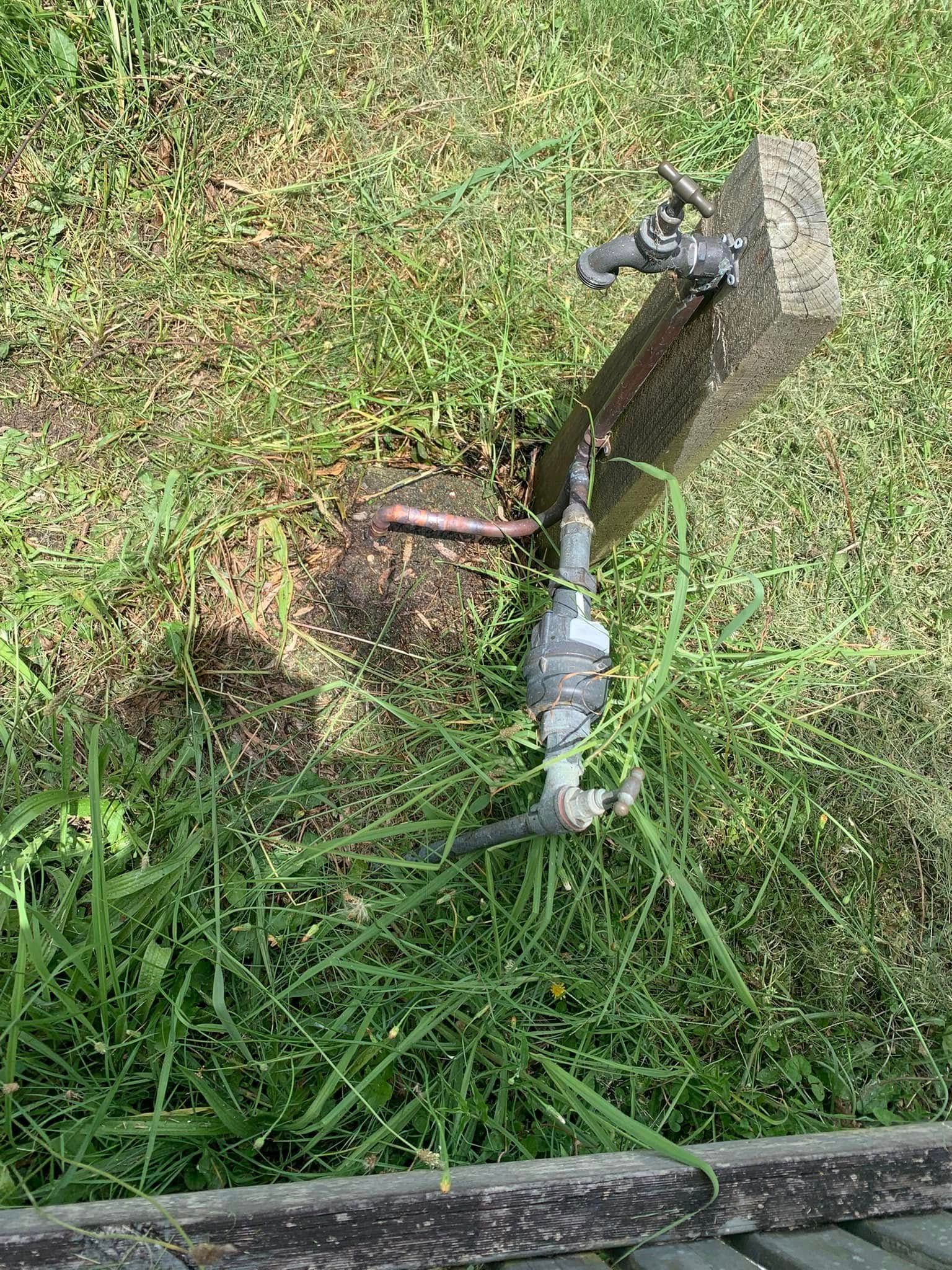 A Faucet is Sitting on the Grass — Delaney Plumbing Services In Taree, NSW