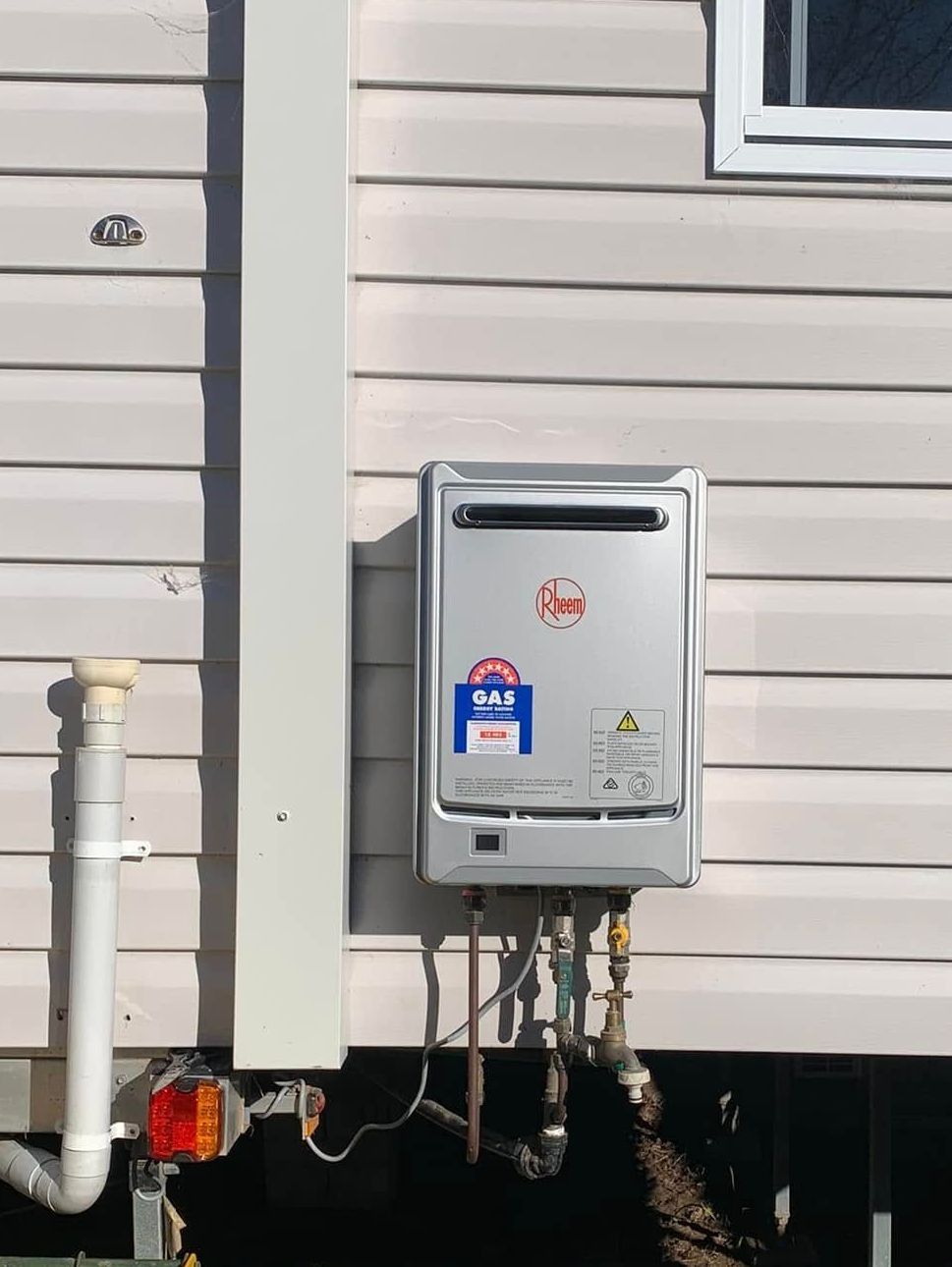 A kitchen gas stove with some cabinets on each side — Delaney Plumbing Services In Old Bar, NSW