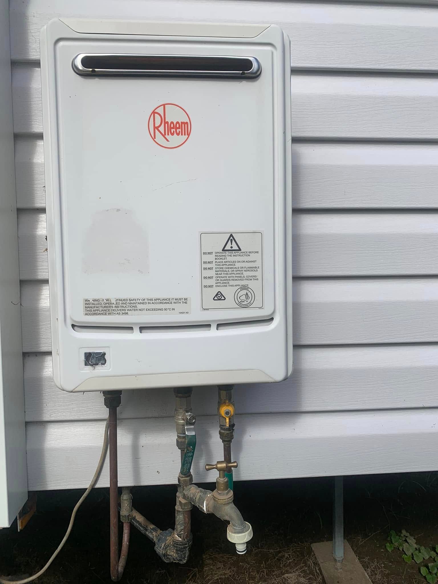 A Gas Water Heating Box fixed on a house cladding  — Delaney Plumbing Services In Wingham, NSW
