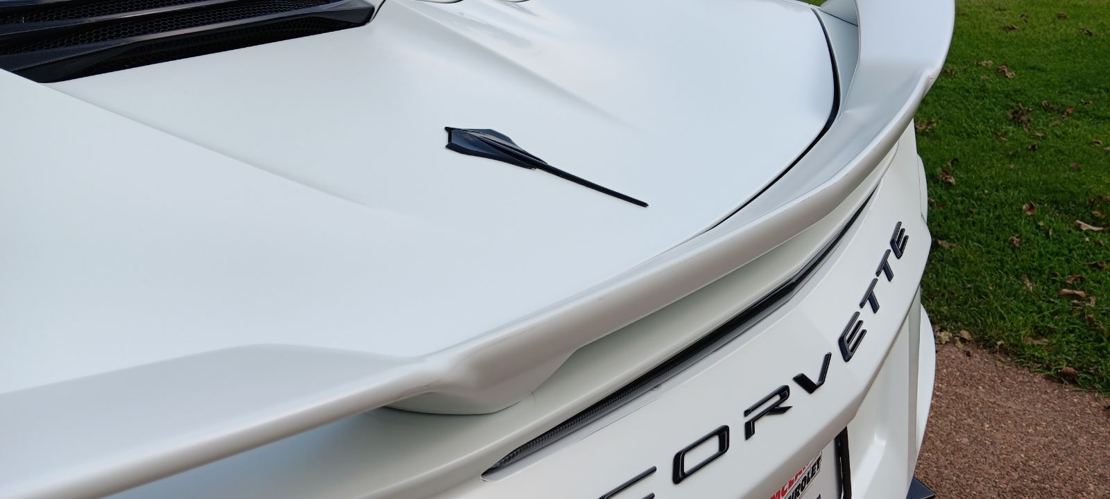 A white corvette is parked on the side of the road.