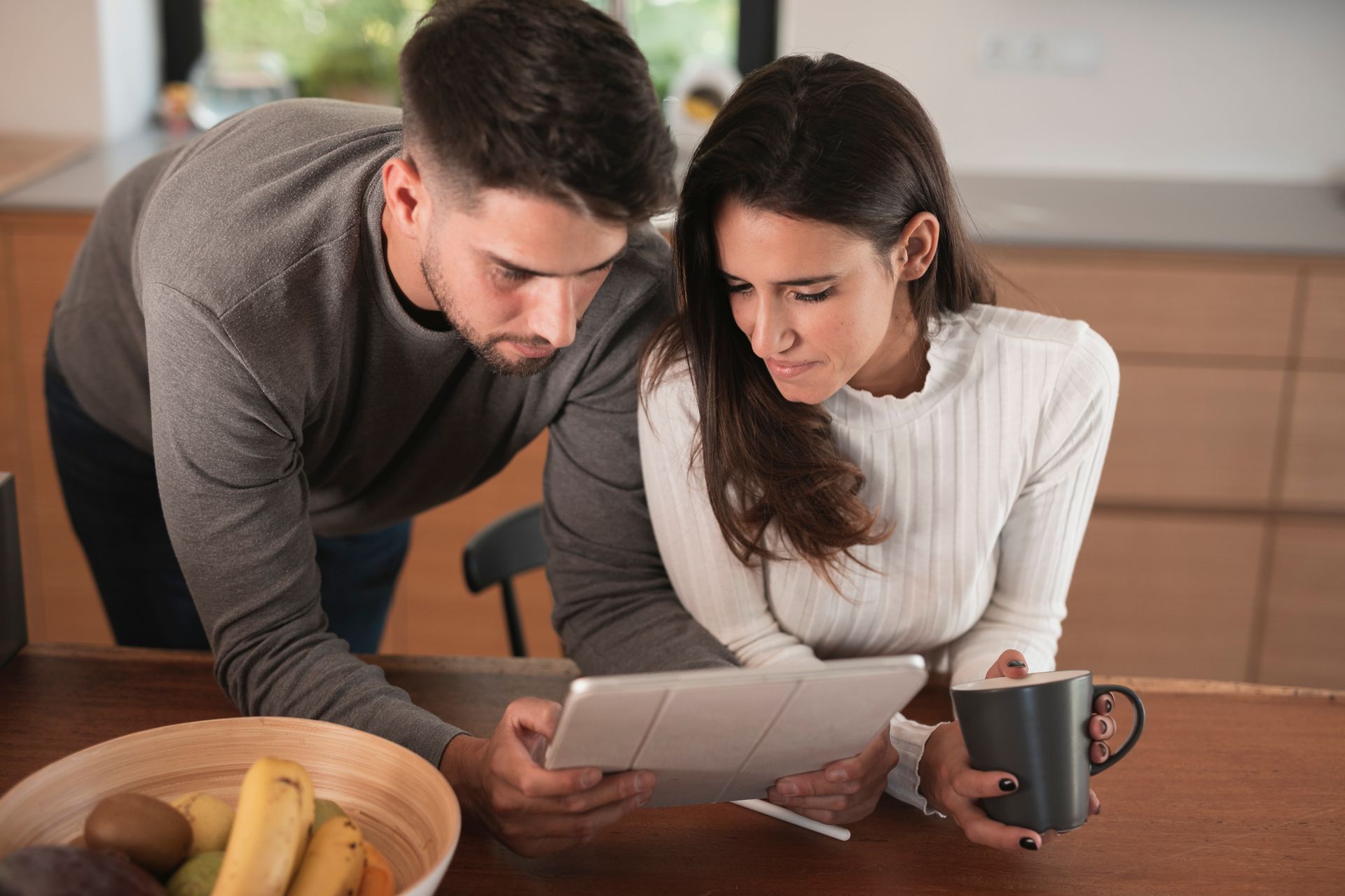 A man and a woman are looking at a tablet computer.