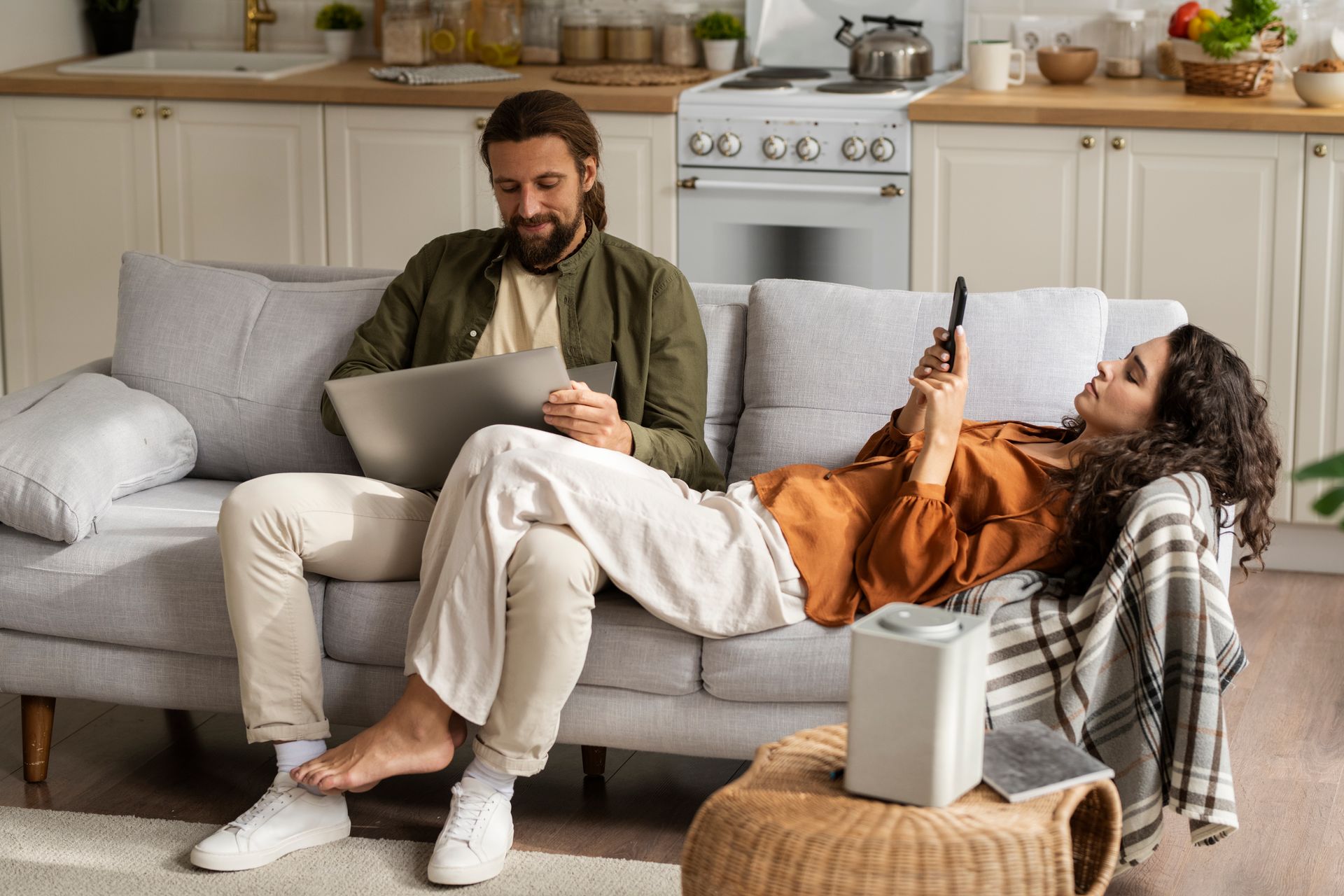A man and a woman are sitting on a couch in a living room.