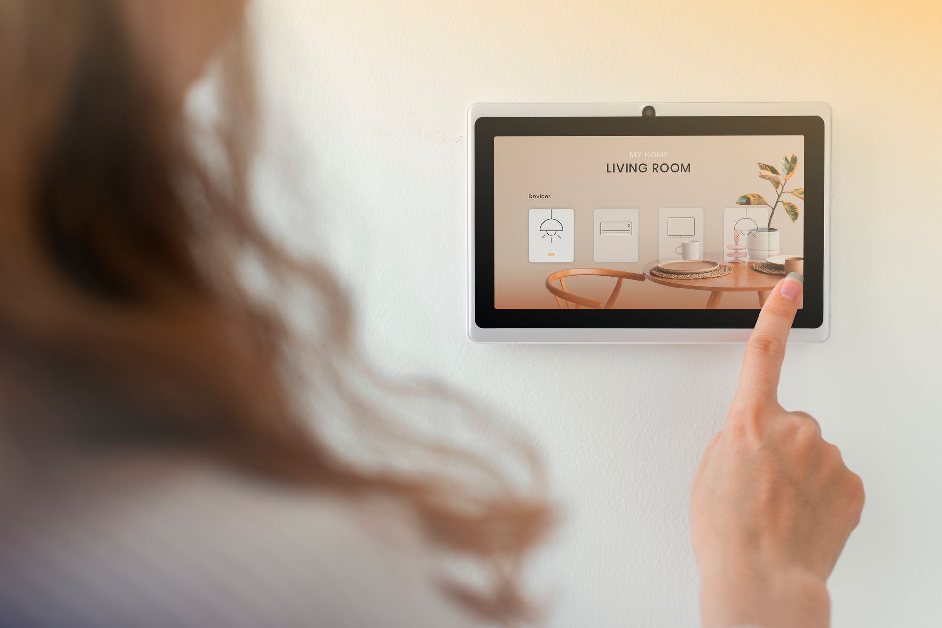 A woman is using a smart device to control her home.