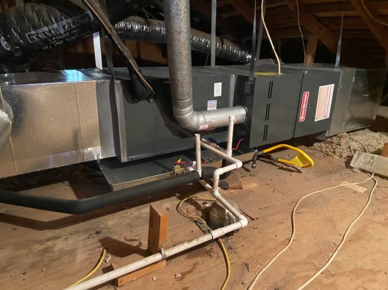 An air conditioner is being installed in the attic of a house.