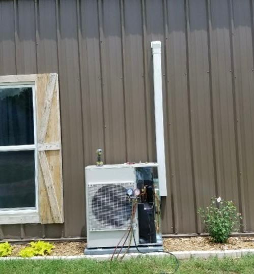 A room with a wooden wall and a ladder hanging from the ceiling.