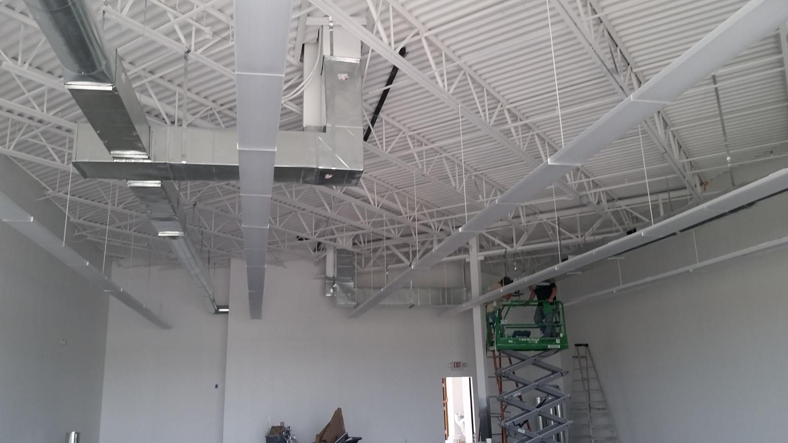 A large room with a lot of ducts hanging from the ceiling.