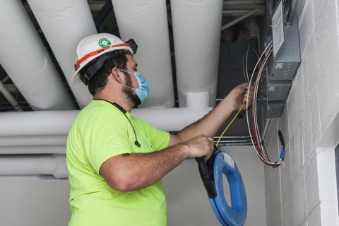 Electrician pulls wires through conduit