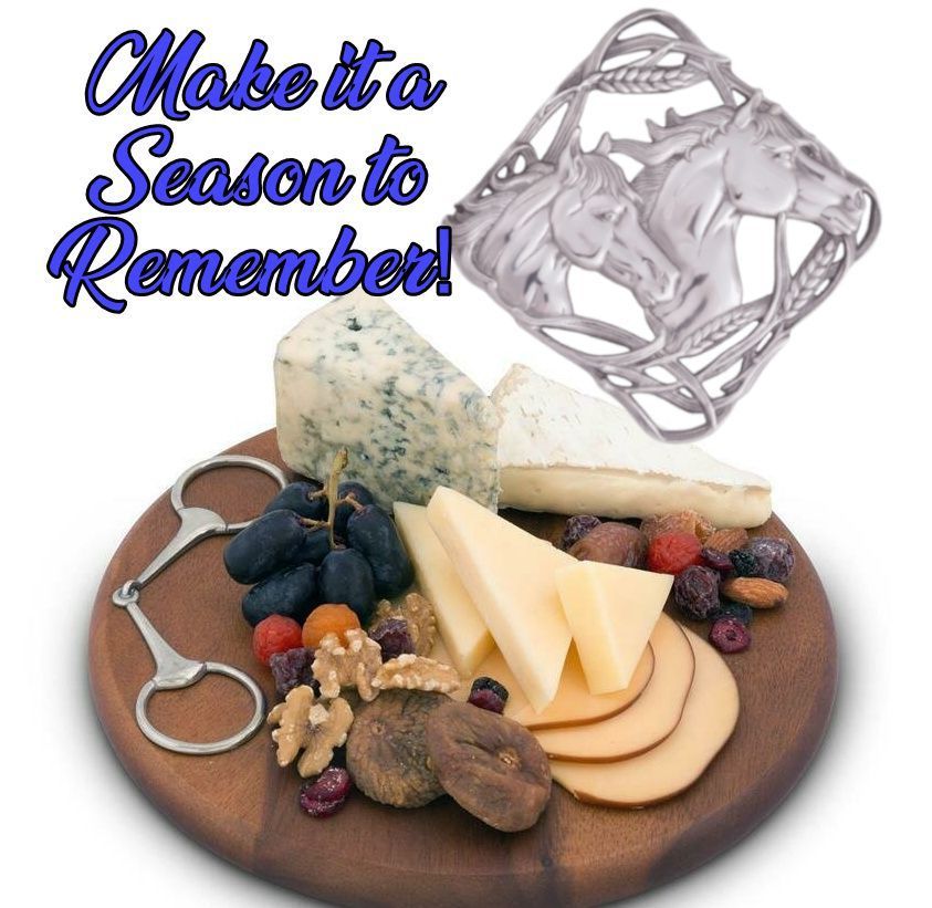 Charcuterie board with cheese, grapes, and nuts; horse-themed brooch.