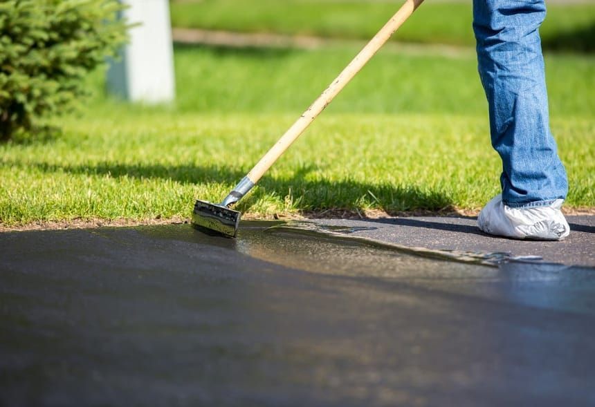 A man wearing gloves is working on a stone wall.