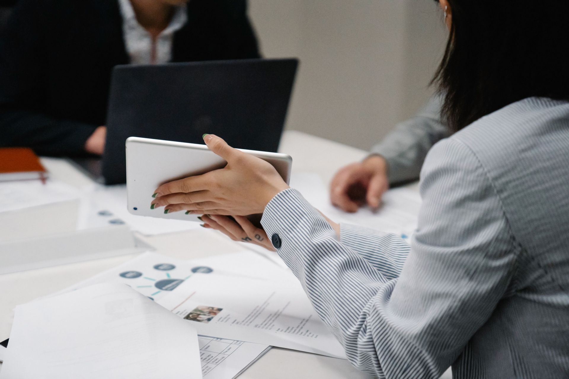 Business meeting with people reviewing documents and using a tablet at a conference table