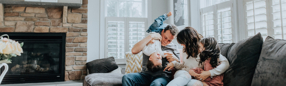 A family is sitting on a couch in a living room.