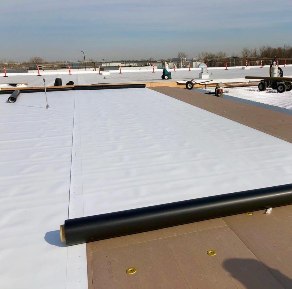 A white roof is being installed on a building