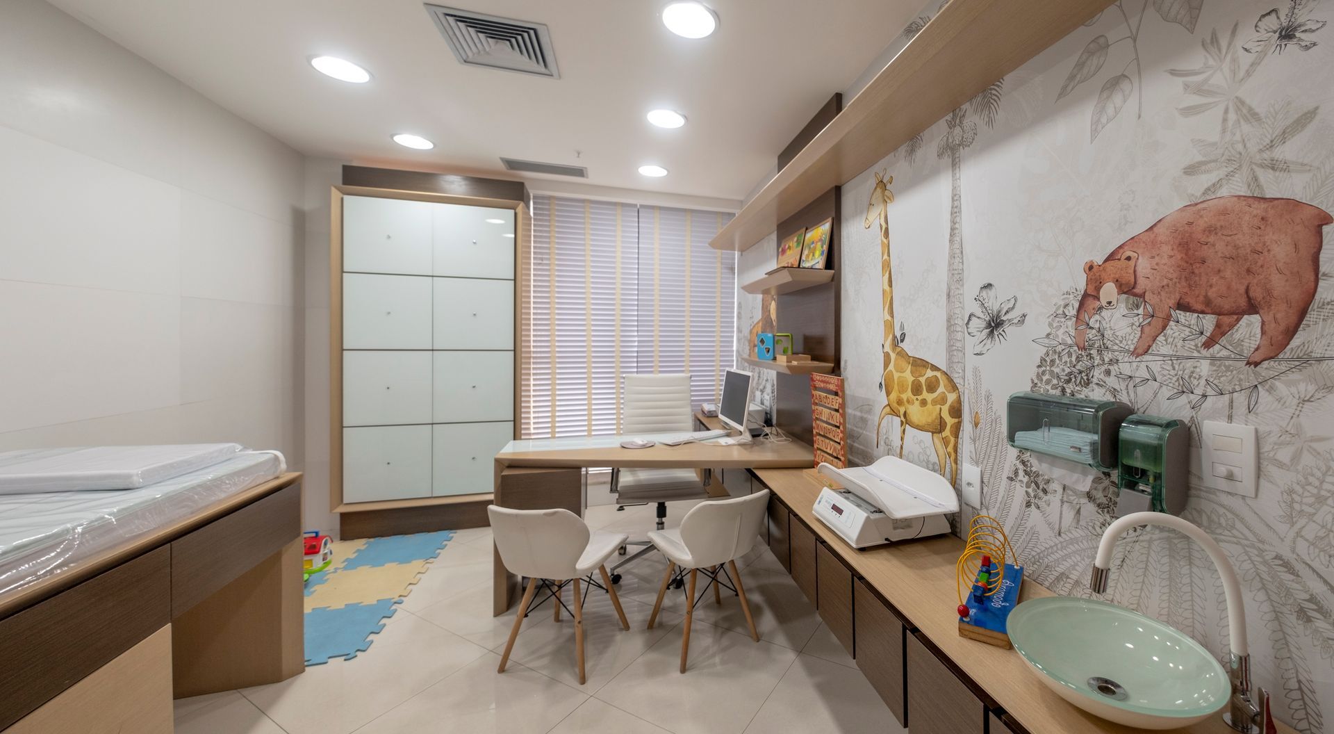 Um consultório médico com uma mesa, cadeiras e uma pia.