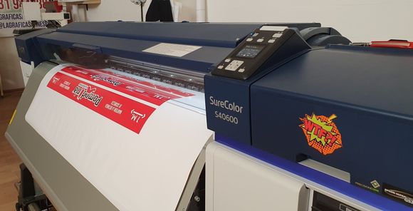 Stampante di grande formato che stampa una grafica rossa e bianca.