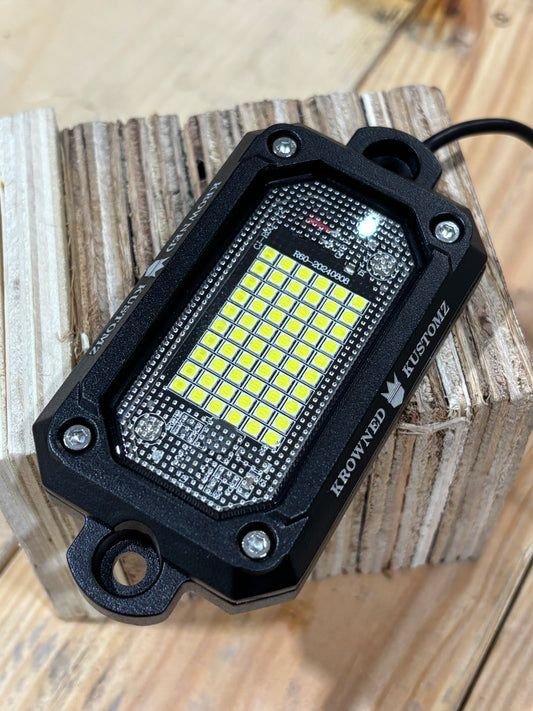 A close up of a led light sitting on top of a wooden table.