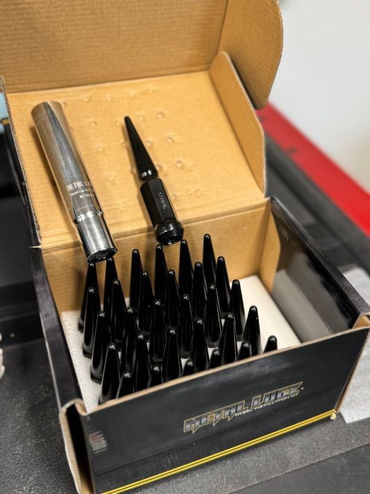 A cardboard box filled with black nuts and bolts