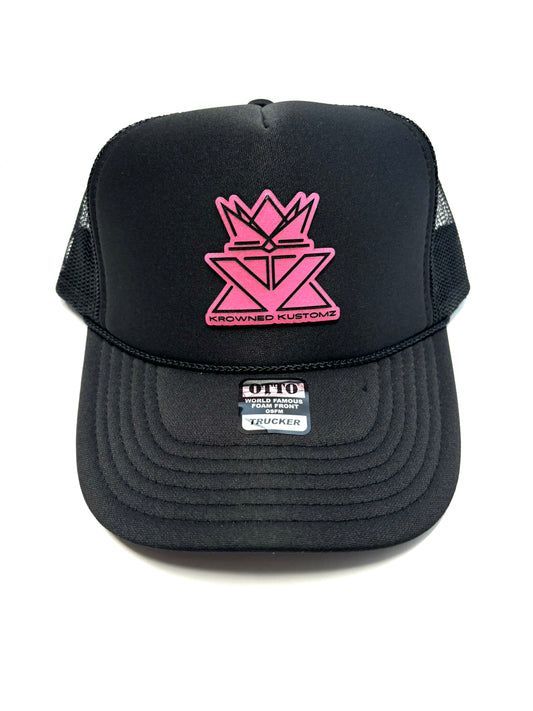 A black trucker hat with a pink crown on it