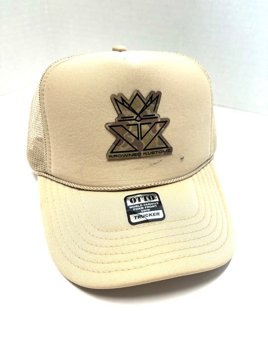 A white trucker hat with a crown on it is sitting on a white table.