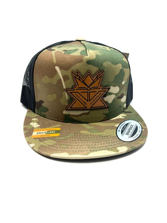 A camouflage hat with a crown on it is on a white background.