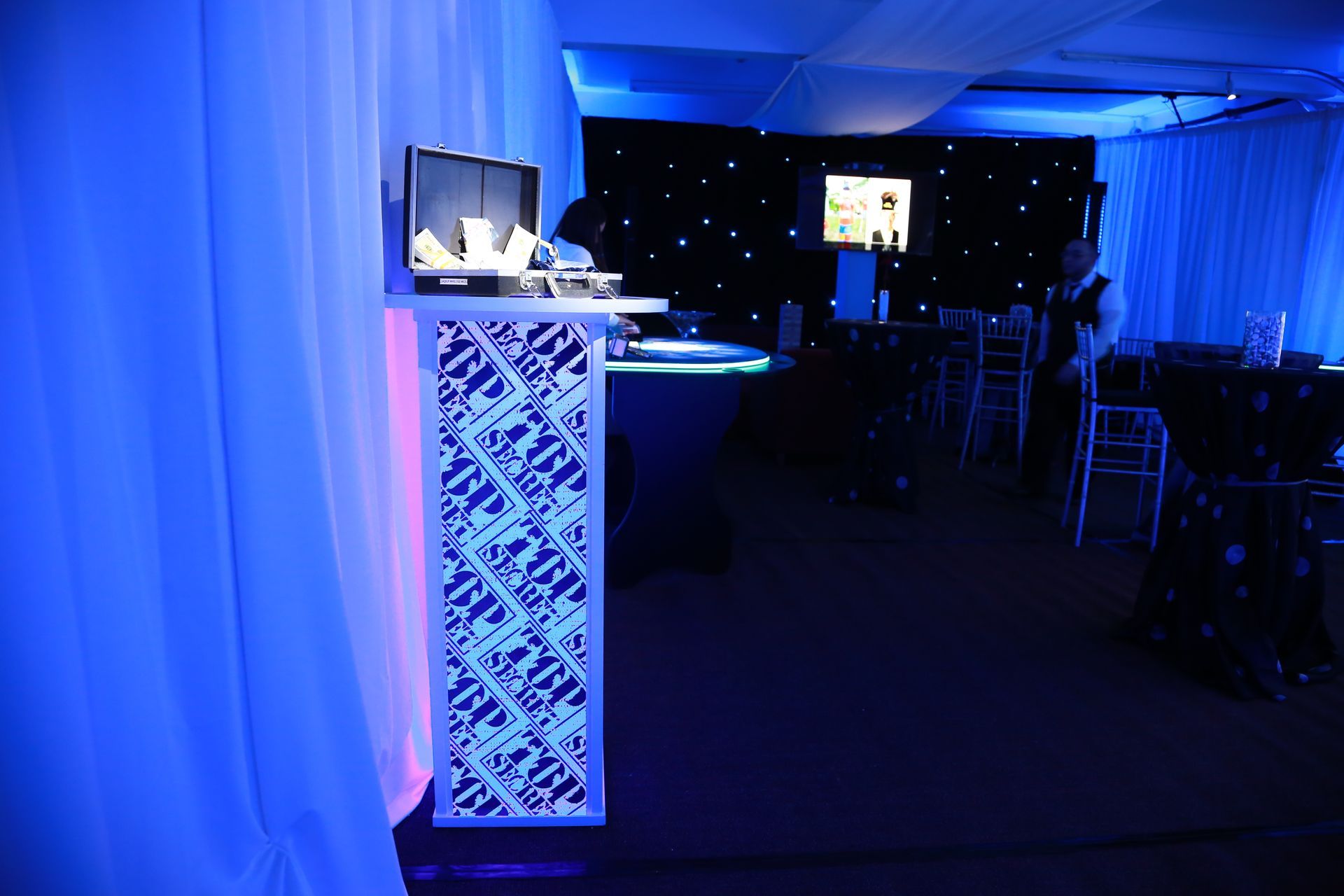 A room with blue lights and a podium that says ' hp ' on it