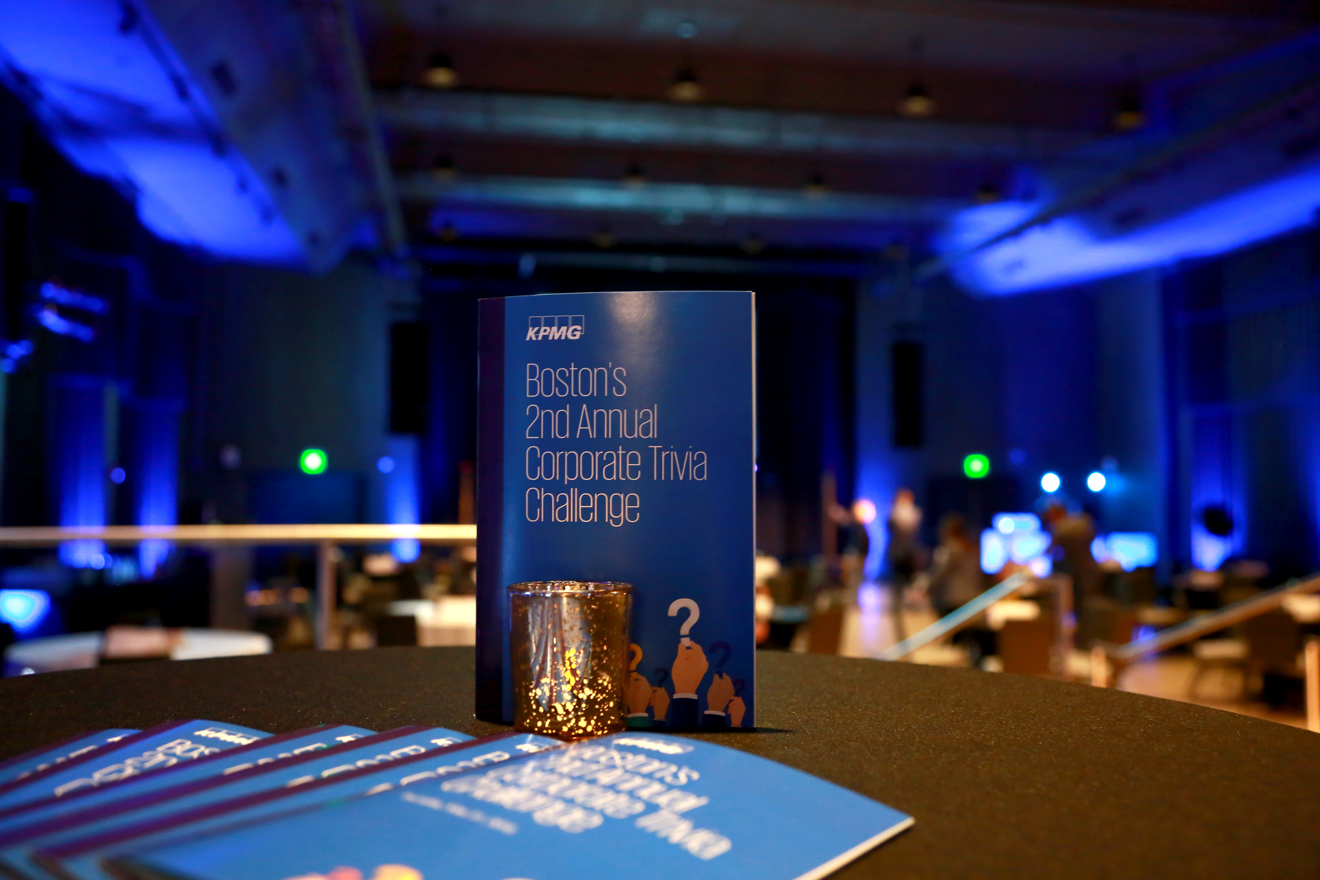 A blue book is sitting on a table in a dark room.