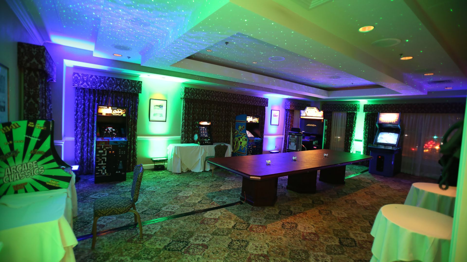 A room filled with tables , chairs , and arcade games.