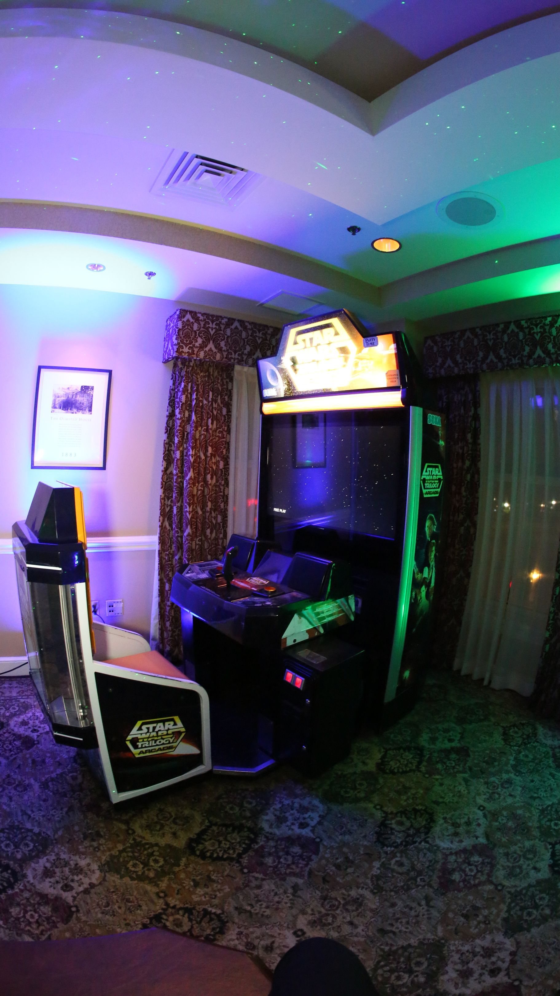 A room with a couch and a video game machine in it.