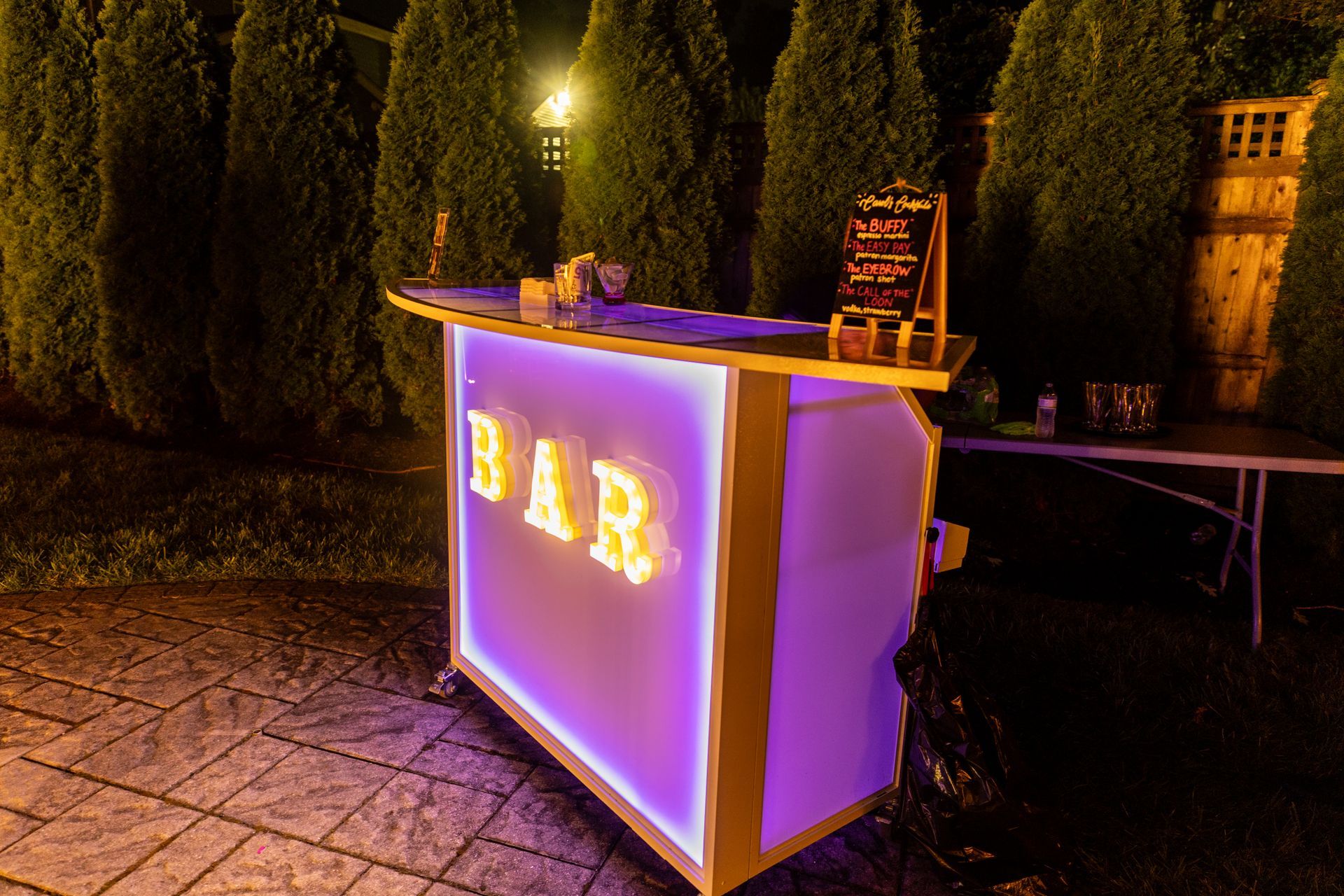 A dj is playing music in a tent next to a pool.
