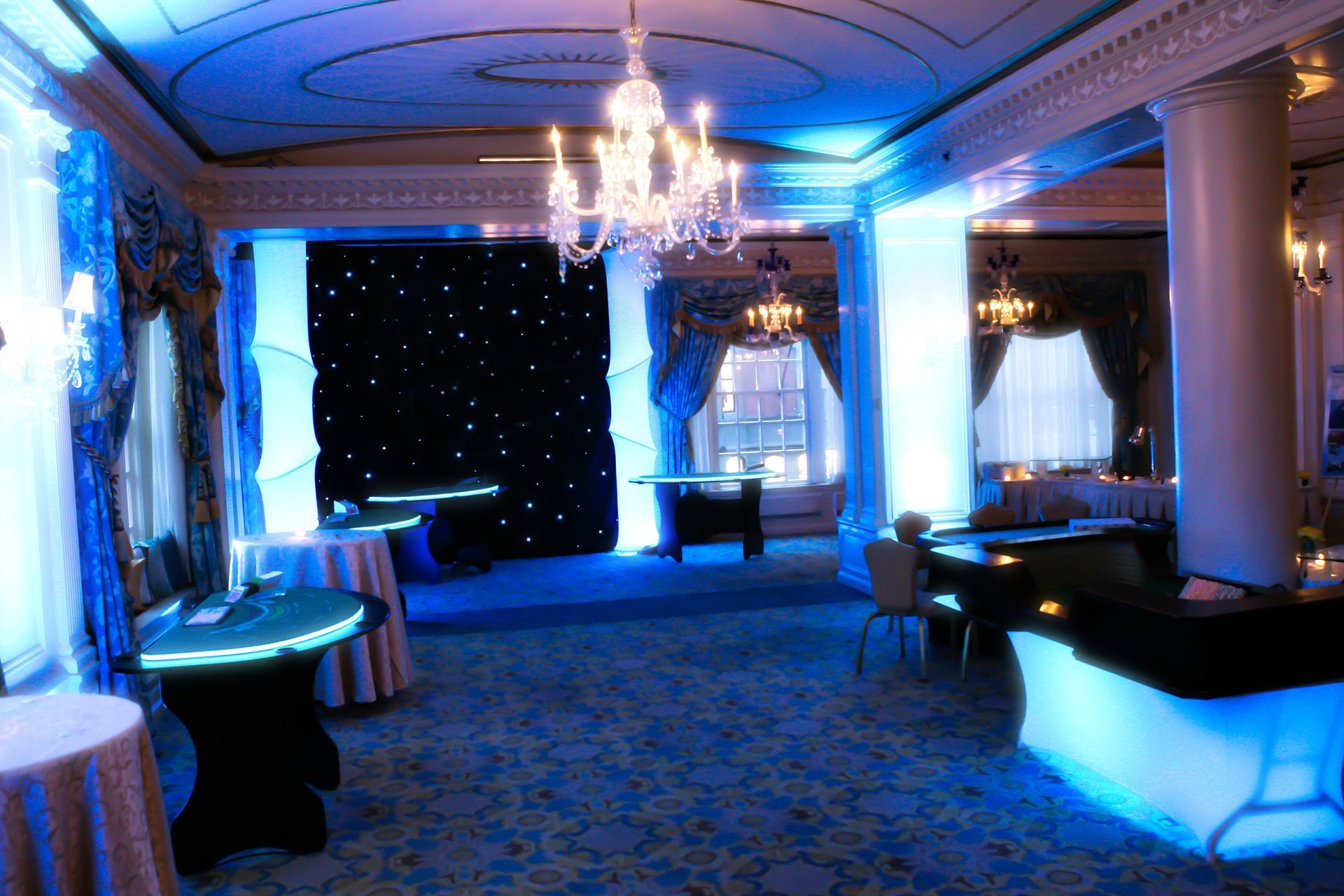 A large room with blue lights and tables and chairs