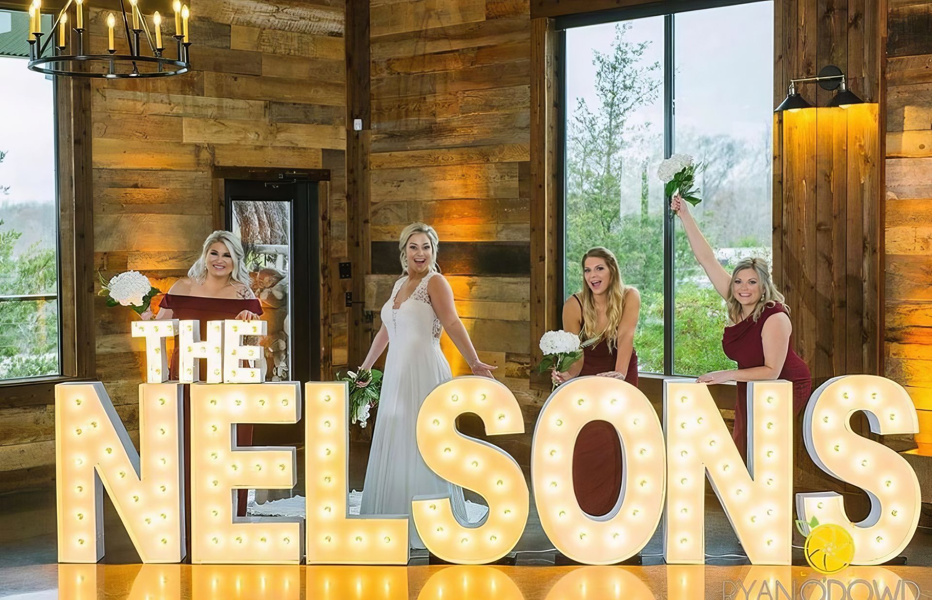 A group of people are dancing in a dark room with their hands in the air.