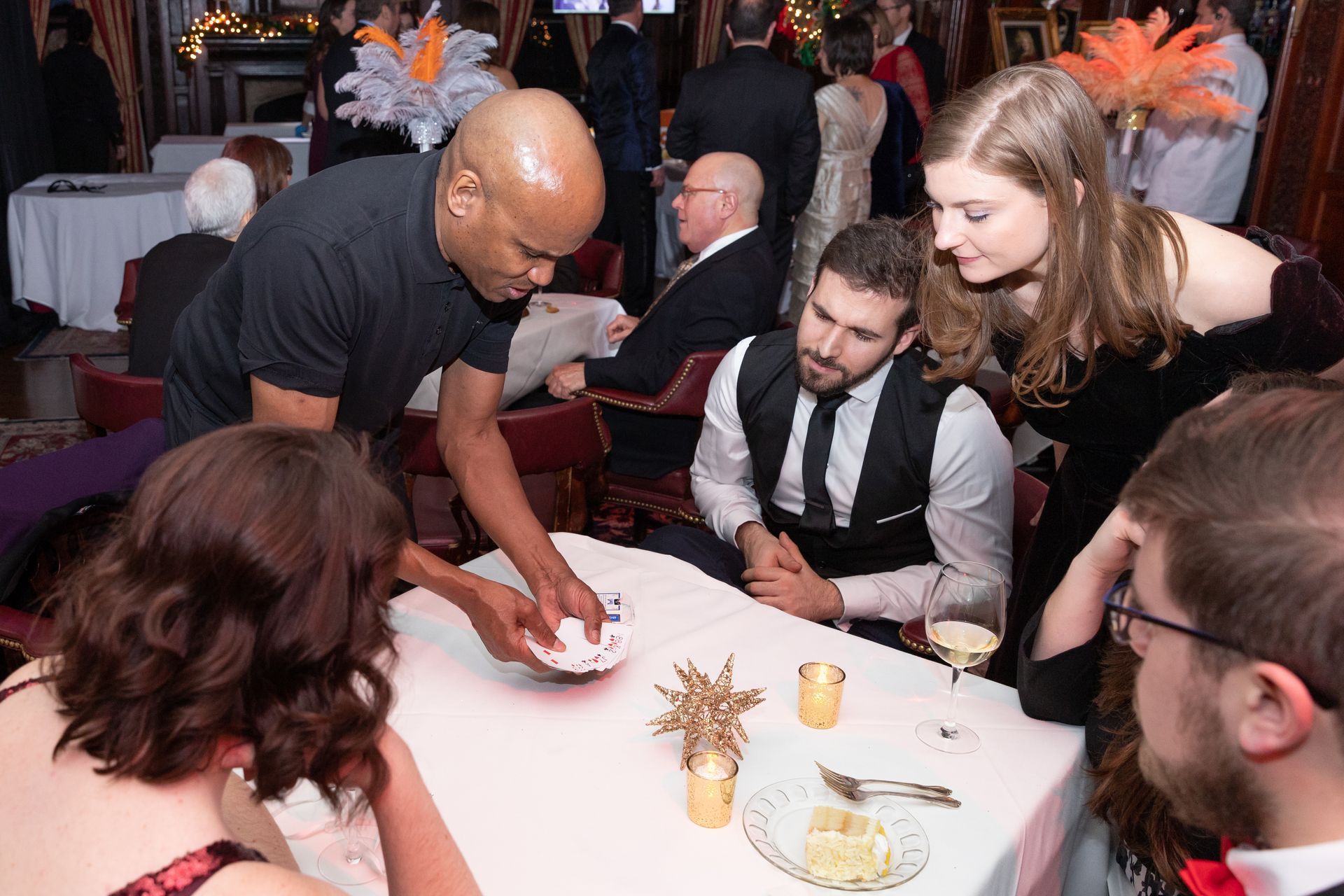 A man is serving food to a group of people at a table.