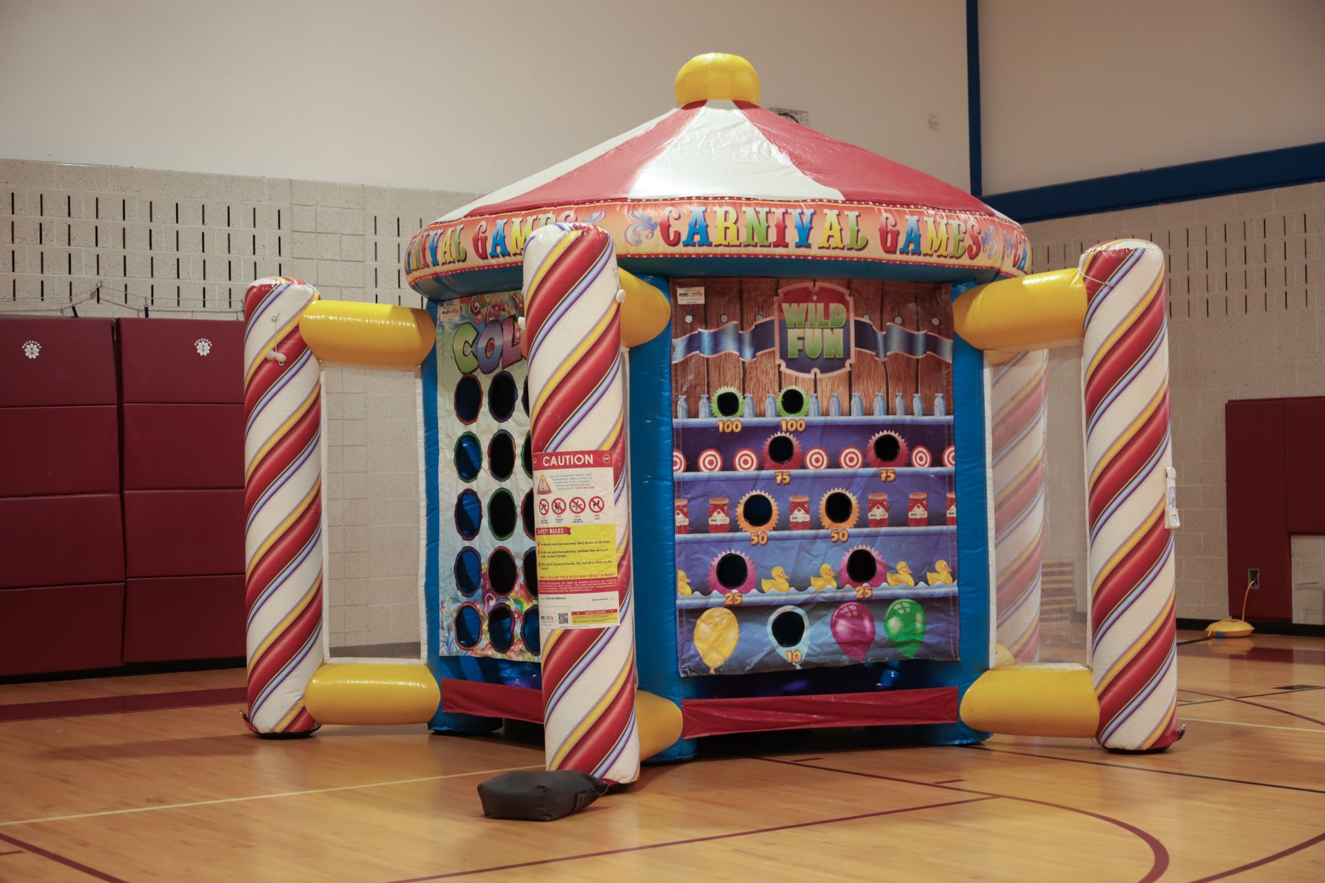 An inflatable carnival game is sitting on a basketball court.
