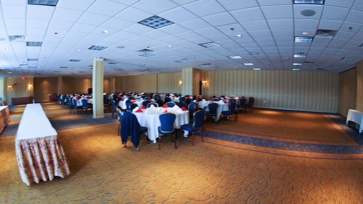 A large room with tables and chairs set up for a banquet.