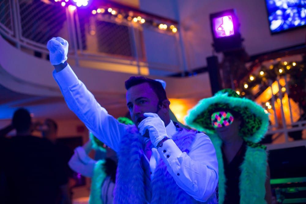 A man is singing into a microphone at a party