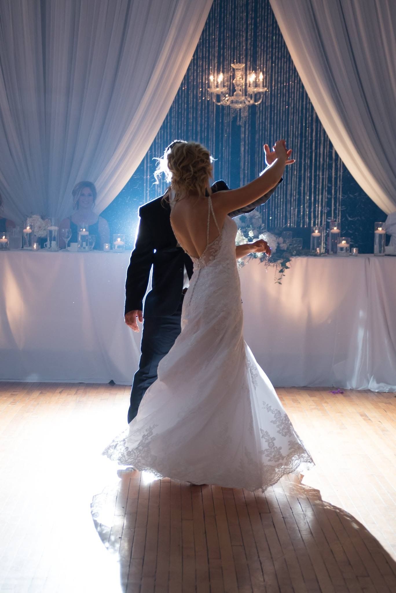 A bride and groom are dancing their first dance at their wedding reception.