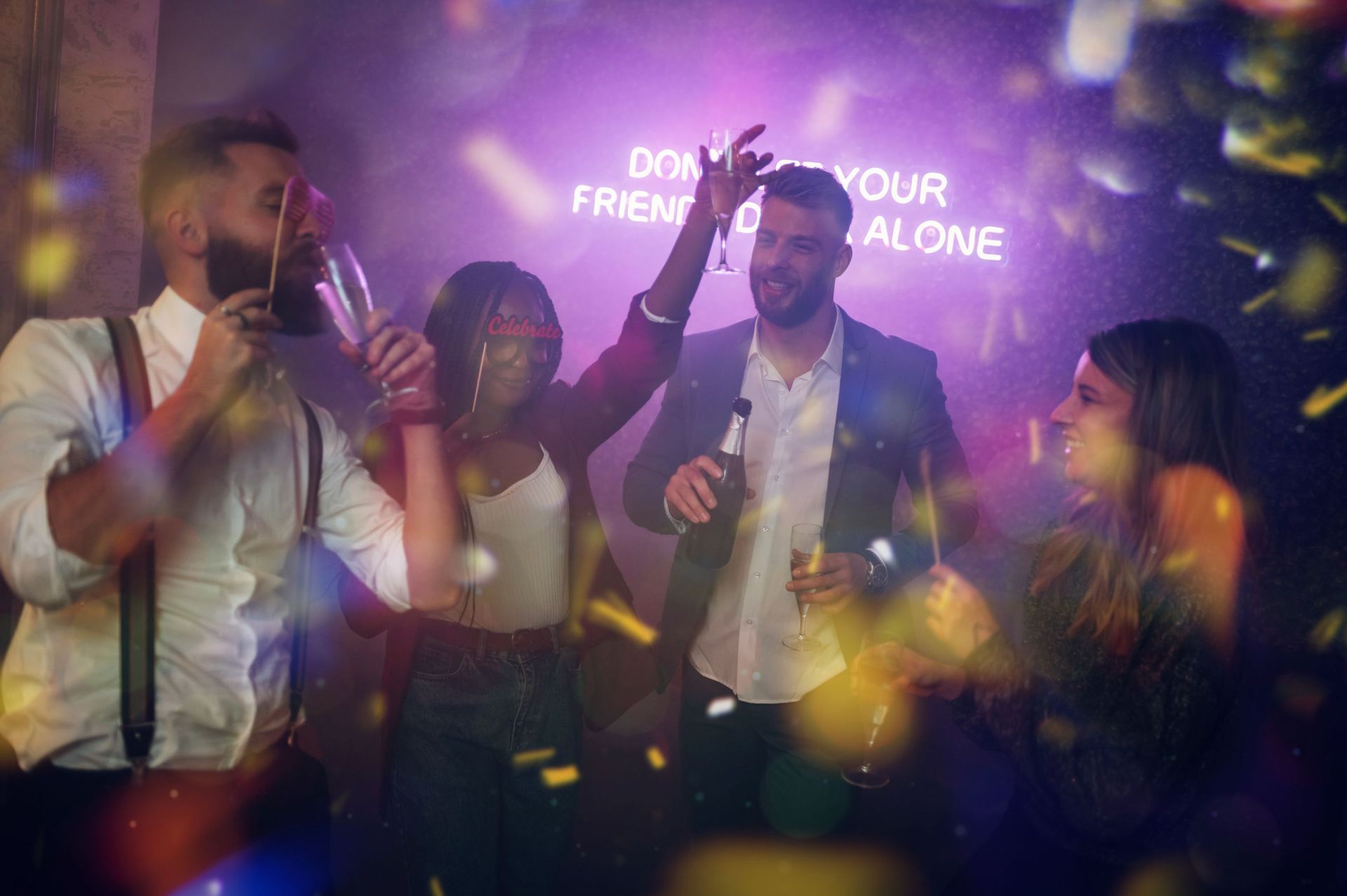 A group of people are dancing and drinking at a party.