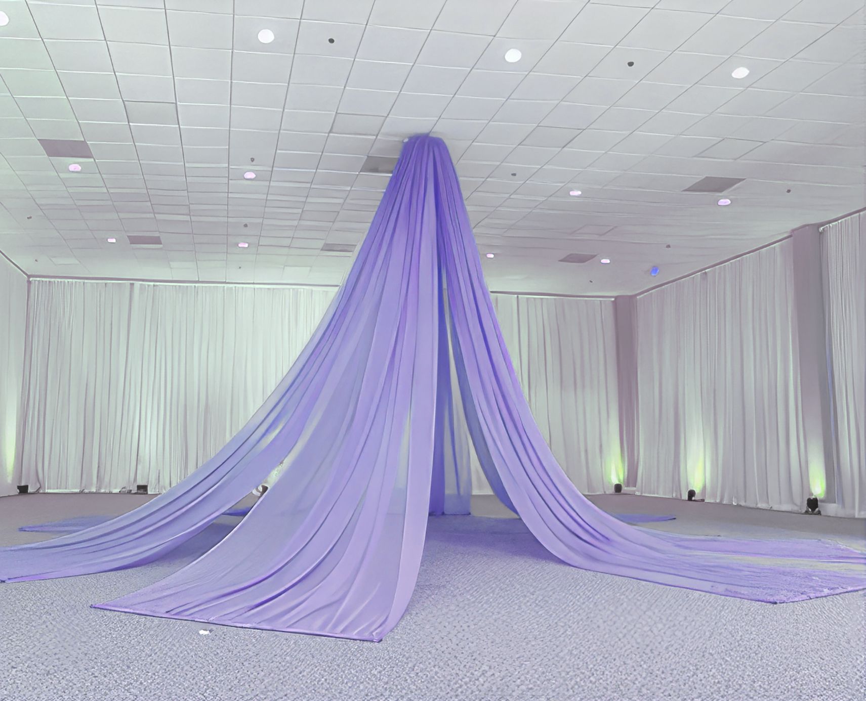 A large purple curtain is hanging from the ceiling of a large room.