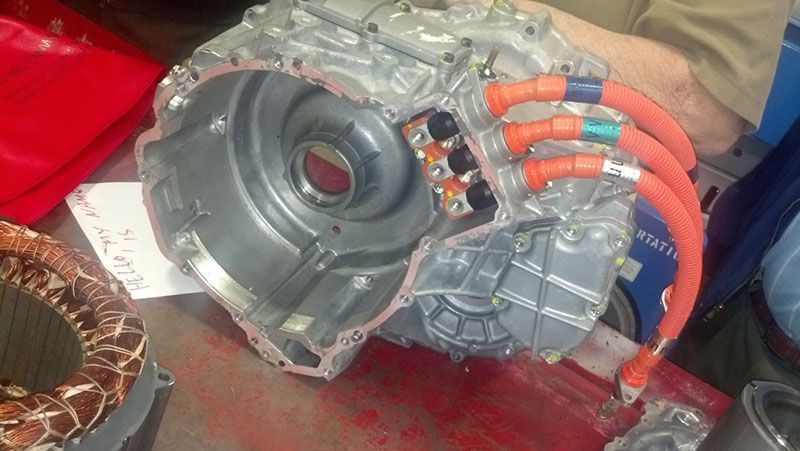 A person is holding a car engine with a bunch of wires attached to it | Autotrends