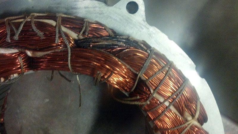 A close up of a copper wire coil on a white surface | Autotrends