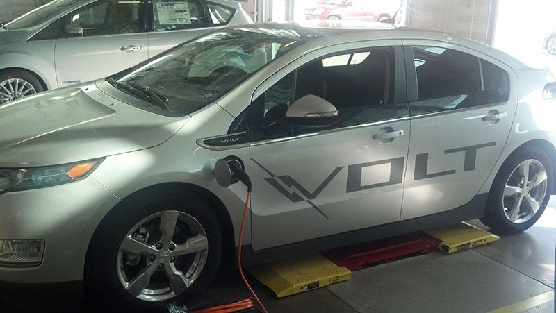A silver volt car is being charged in a garage | Autotrends