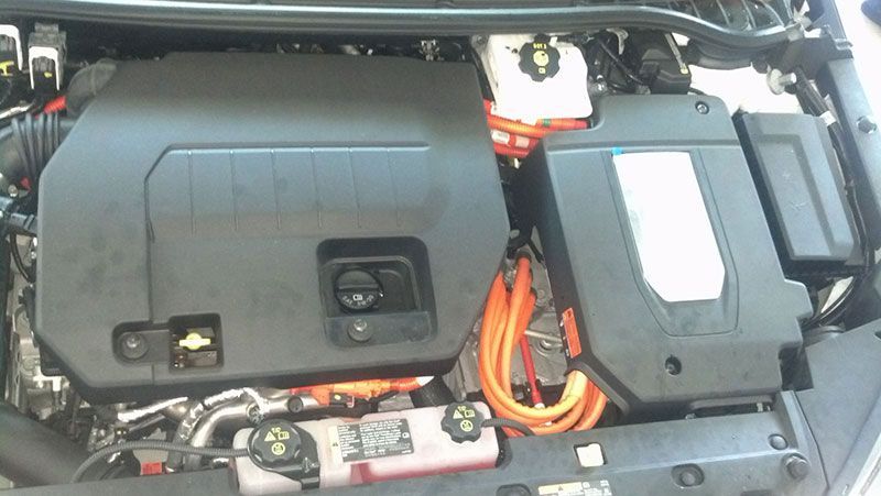 The engine of a car with orange wires coming out of it | Autotrends