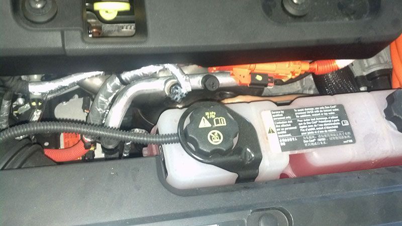 A close up of a car engine with a warning label on it | Autotrends