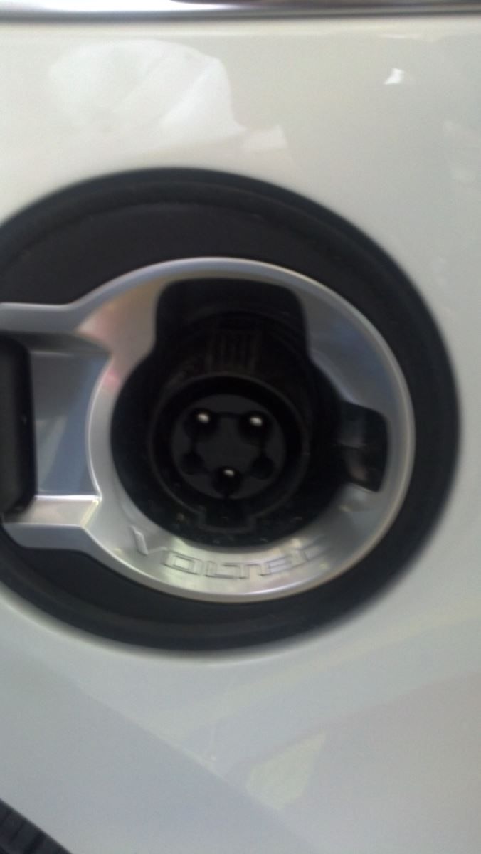 A close up of a charging port on a white car | Autotrends