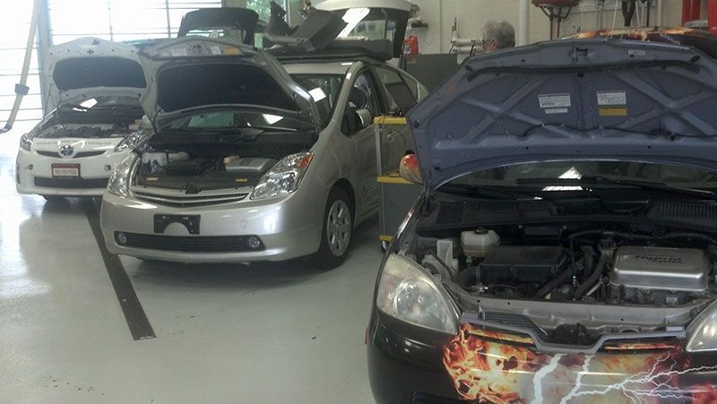 A row of cars with their hoods open in a garage | Autotrends